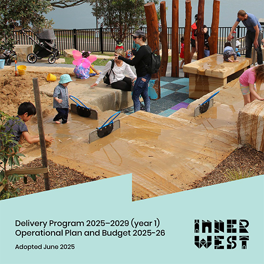 Children and parents playing in a modern playground with sandstone seating.